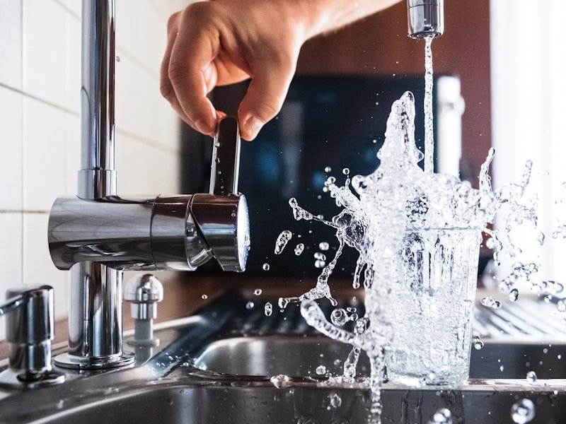 Water cascading from a kitchen tap — drain cleaning and hydro-jetting service.